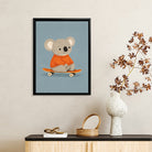 Framed Art Print of a Cute Koala in an Orange Sweater Riding a Skateboard, Perfect for Nursery or Home Decor